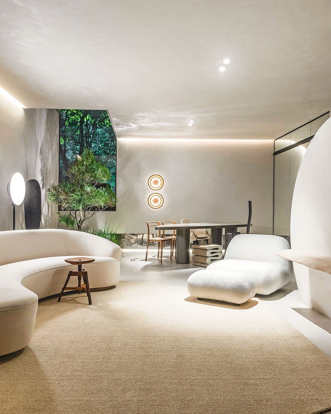 Lounge do OCEAM 4, com sofá curvo, zona de refeições ao fundo e envidraçado sobre o jardim interior.